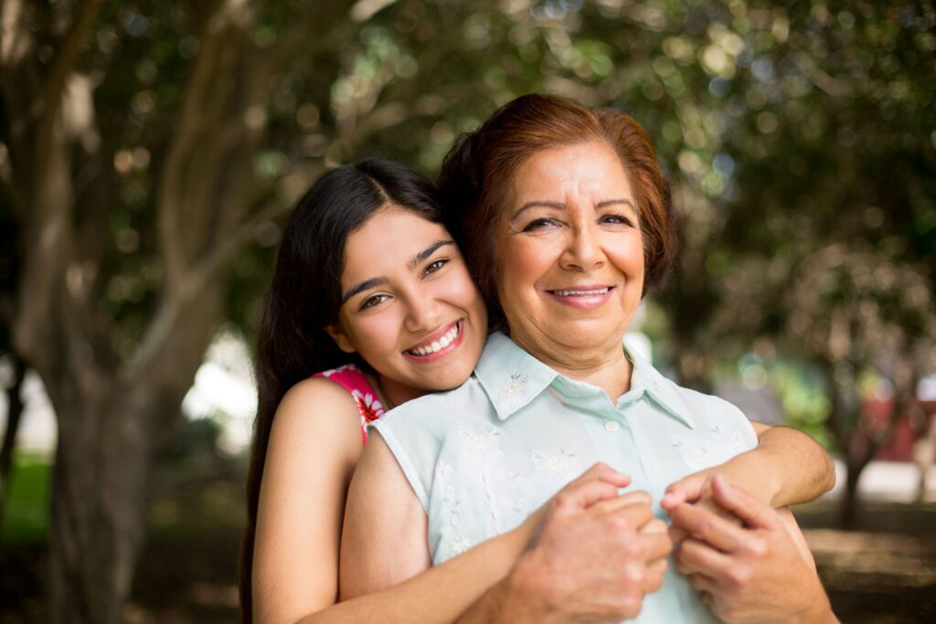 Granddaughter hugging her grandmother from behind